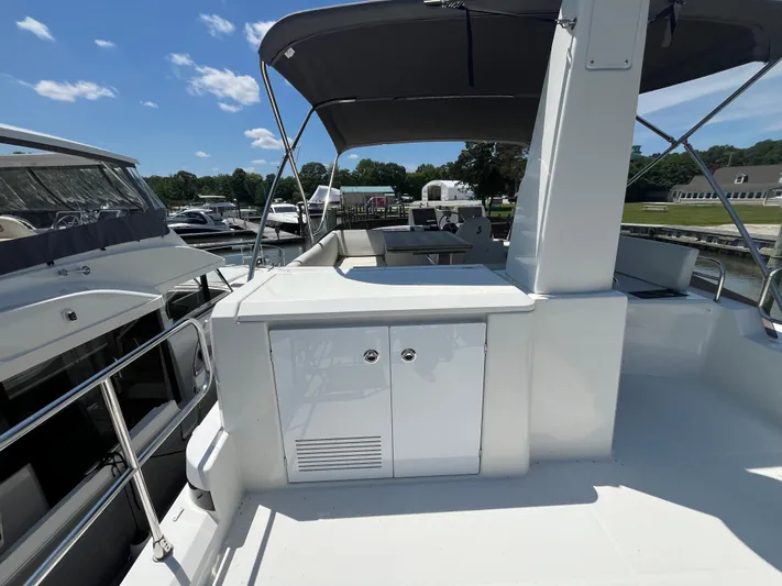  Yacht Photos Pics 2023 Beneteau Swift Trawler 41 Fly, spacious deck with canopy, docked at marina.