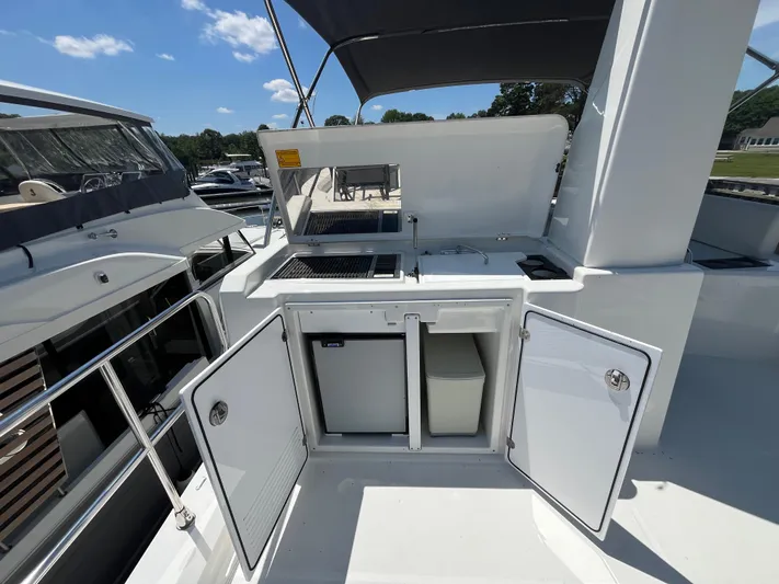  Yacht Photos Pics 2023 Beneteau Swift Trawler 41 Fly outdoor kitchenette with storage and appliances.