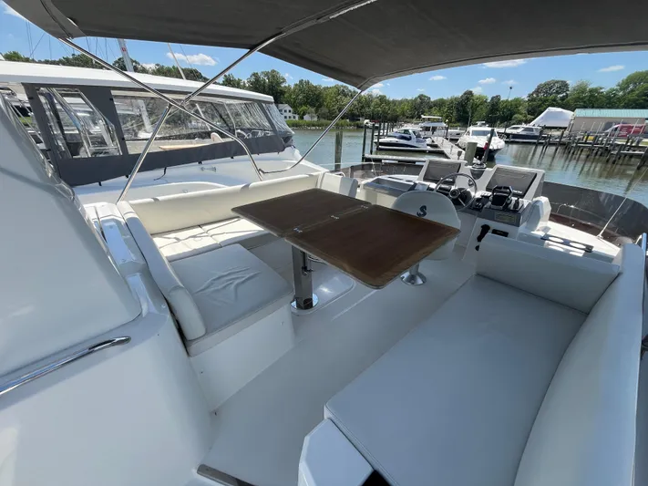  Yacht Photos Pics 2023 Beneteau Swift Trawler 41 Fly, featuring a spacious outdoor seating area with a wooden table.