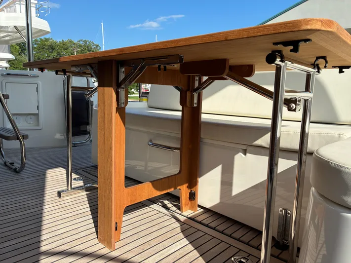  Yacht Photos Pics 2023 Beneteau Swift Trawler 41 Fly deck with wooden table and seating.