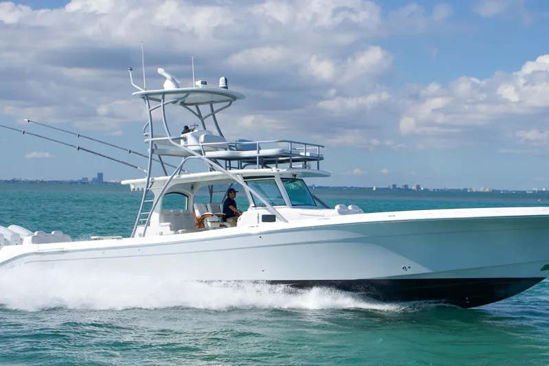  Yacht Photos Pics 2023 HCB 53 Sue&ntilde;os boat cruising on clear blue ocean under a partly cloudy sky.