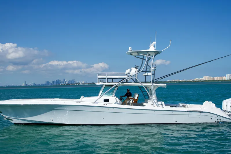  Yacht Photos Pics 2023 HCB 53 Sue&ntilde;os boat cruising on blue ocean with city skyline in background.