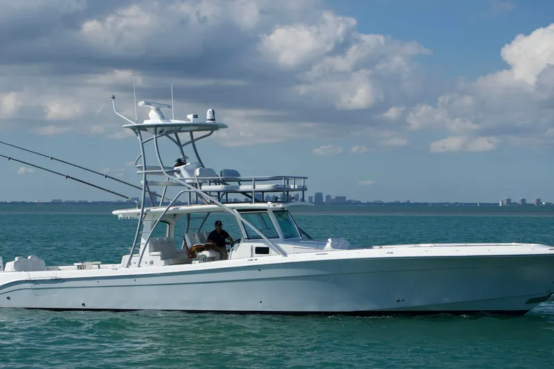  Yacht Photos Pics 2024 HCB 53 Sueños boat cruising on calm ocean waters under a partly cloudy sky.