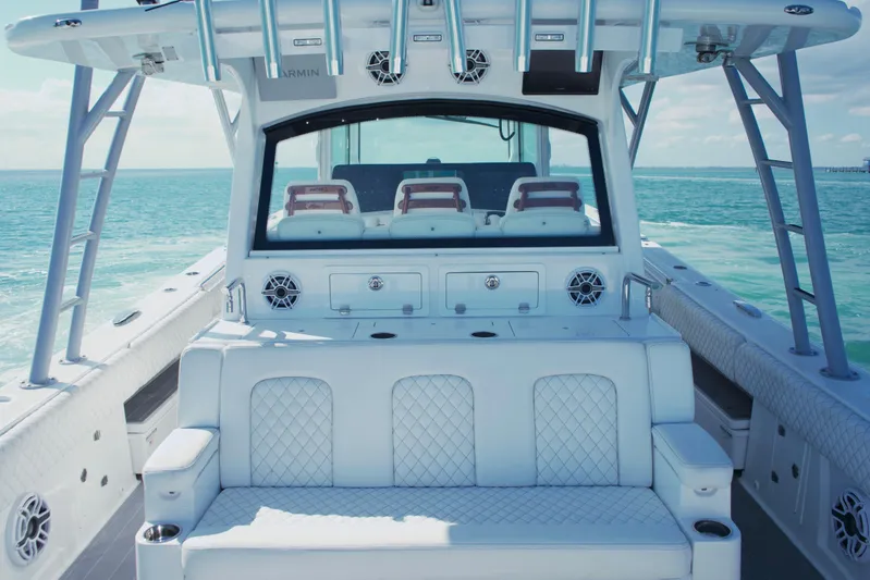  Yacht Photos Pics Luxurious 2024 HCB 53 Sueños boat interior with plush seating, cruising on clear blue waters.