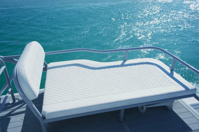  Yacht Photos Pics Luxury sunbed on 2024 HCB 53 Sueños yacht, overlooking sparkling blue ocean.