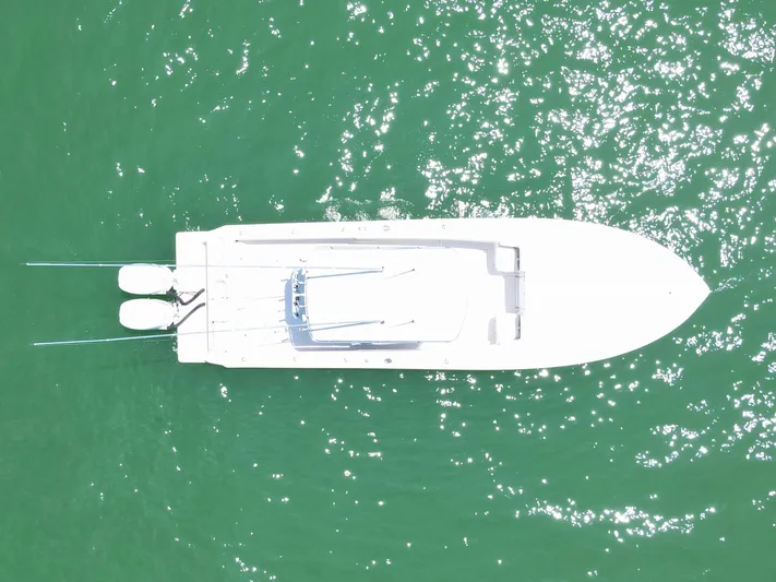  Yacht Photos Pics Aerial view of 2005 Contender 31 Cuddy boat on sparkling green water.