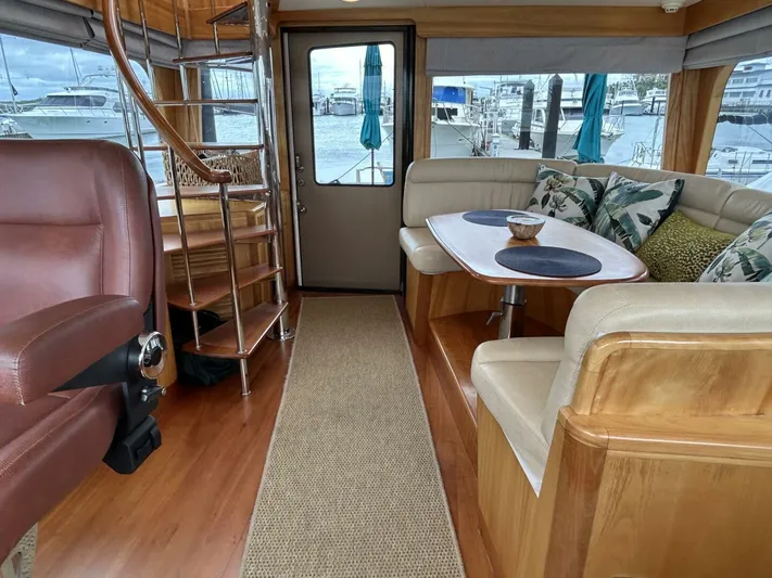 Alacrity Yacht Photos Pics Luxurious interior of 2008 Lyman-Morse Flybridge 62' yacht with elegant seating and spiral staircase.