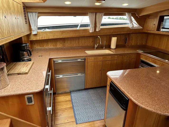 Alacrity Yacht Photos Pics Luxurious kitchen interior of 2008 Lyman-Morse Flybridge 62' yacht with wood cabinetry and modern appliances.