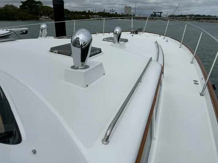 Alacrity Yacht Photos Pics 2008 Lyman-Morse Flybridge 62' yacht deck with chrome fixtures and railing, docked in a marina.