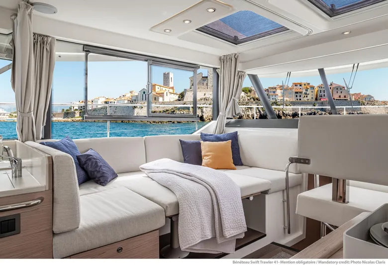 In Stock Yacht Photos Pics 2024 Beneteau Swift Trawler 41 Sedan interior with coastal view, featuring comfortable seating and modern design.
