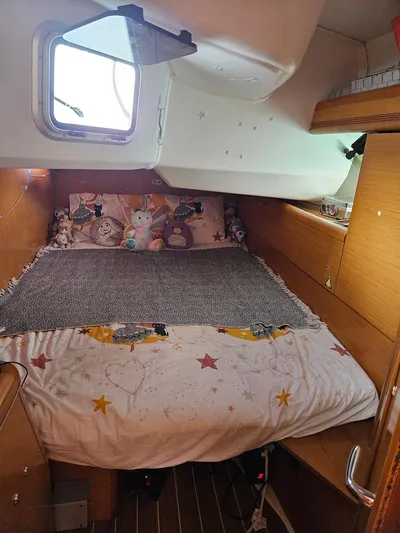 Helix Yacht Photos Pics Cozy cabin interior of 2011 Jeanneau 44i sailboat with plush bedding and wooden accents.