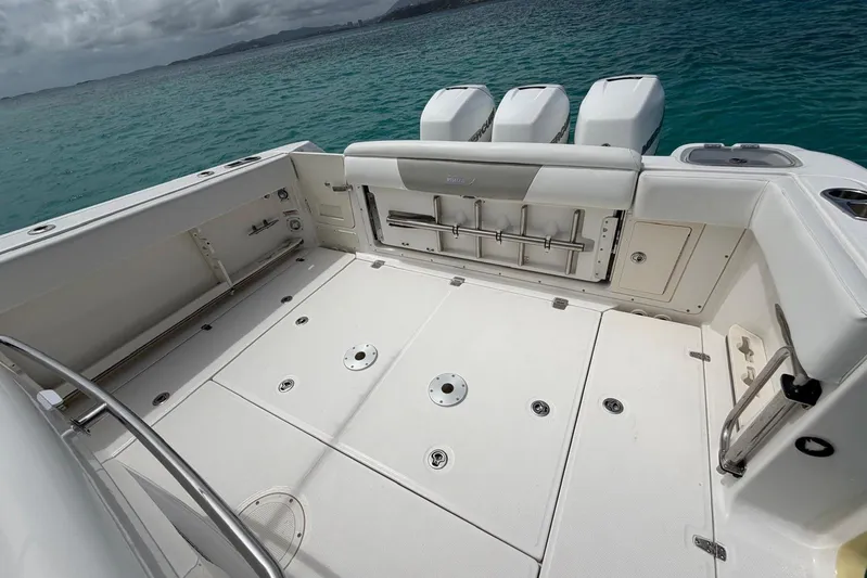  Yacht Photos Pics 2010 Boston Whaler 370 Outrage boat deck with triple engines, on clear blue water.