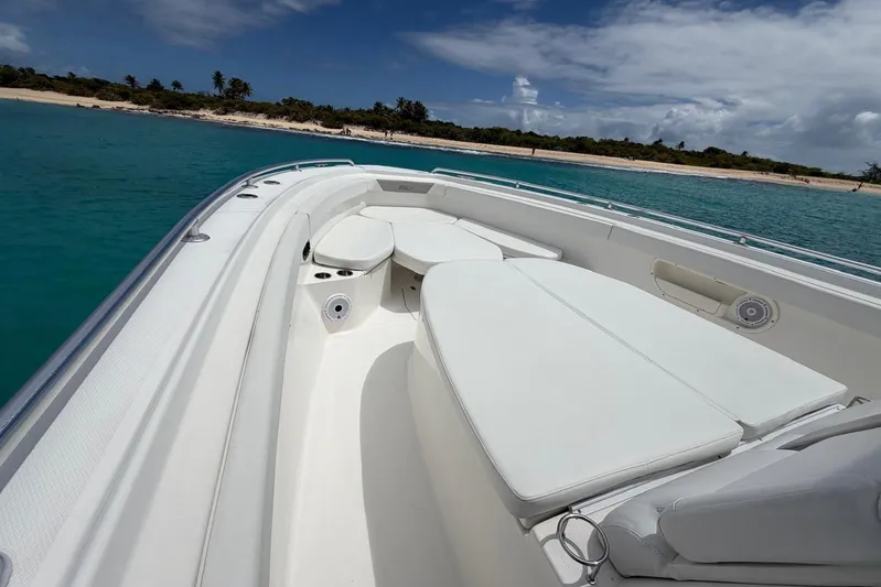  Yacht Photos Pics Boston Whaler 370 Outrage 2010 boat with white seating, anchored near a tropical beach.