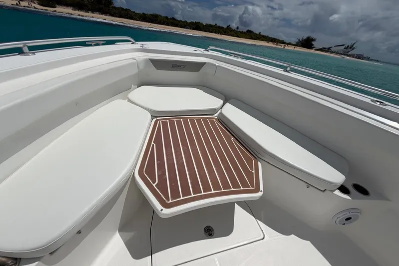  Yacht Photos Pics 2010 Boston Whaler 370 Outrage boat interior with cushioned seating and wooden table.