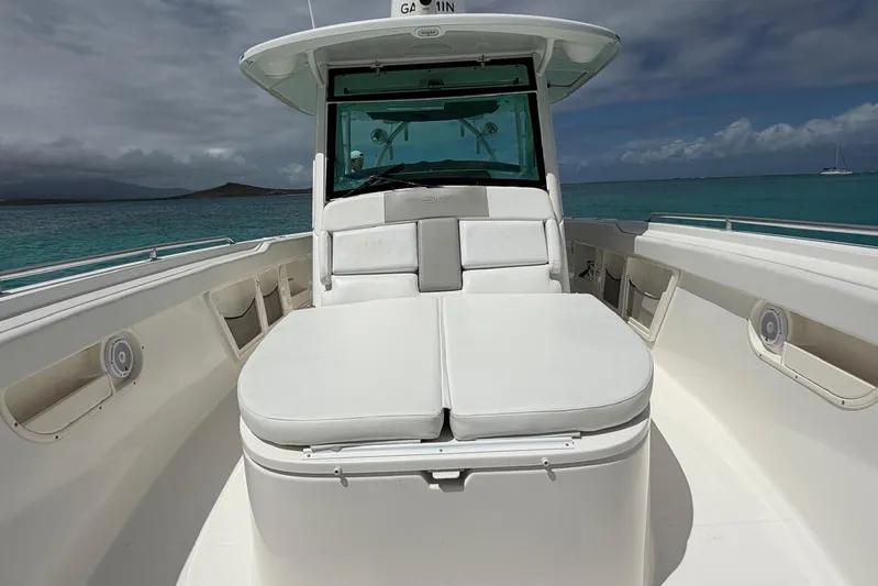  Yacht Photos Pics 2010 Boston Whaler 370 Outrage boat with white seating, on calm turquoise waters.