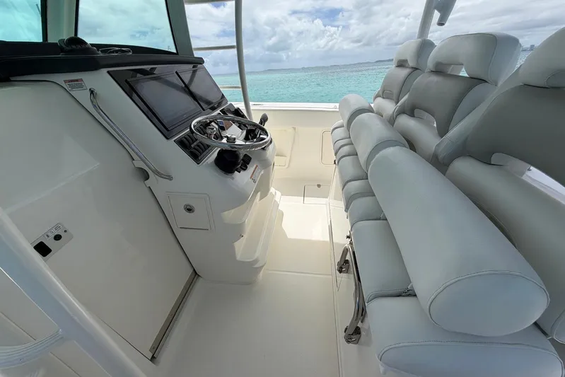  Yacht Photos Pics 2010 Boston Whaler 370 Outrage helm with modern controls and seating, overlooking clear ocean waters.