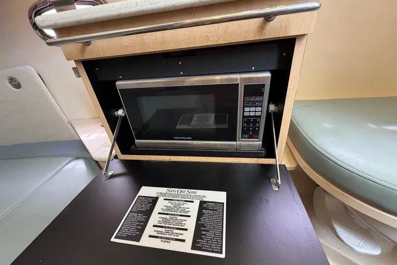  Yacht Photos Pics 2010 Boston Whaler 370 Outrage interior with microwave and informational sign.