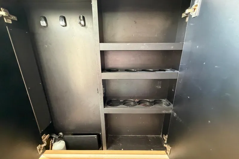  Yacht Photos Pics Storage cabinet inside a 2010 Boston Whaler 370 Outrage boat, featuring shelves and hooks.