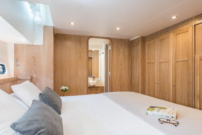 Sasga Yachts 68 Flybridge Yacht Photos Pics Luxurious bedroom in 2026 Sasga Yachts Menorquin 68 FB with wooden decor and cozy bedding.