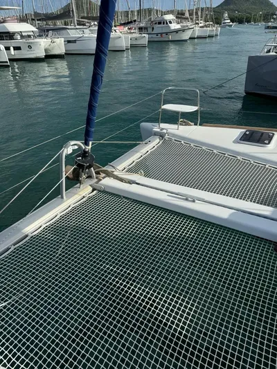 Oscar III Yacht Photos Pics 2018 Lagoon 380 catamaran docked in a marina, featuring netted deck and sail rigging.