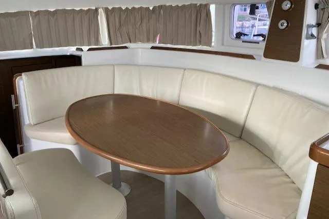 Oscar III Yacht Photos Pics Interior of 2018 Lagoon 380 yacht with curved seating and wooden table.