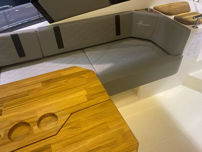  Yacht Photos Pics 2025 Hanover 387 boat interior with gray seating and wooden table.