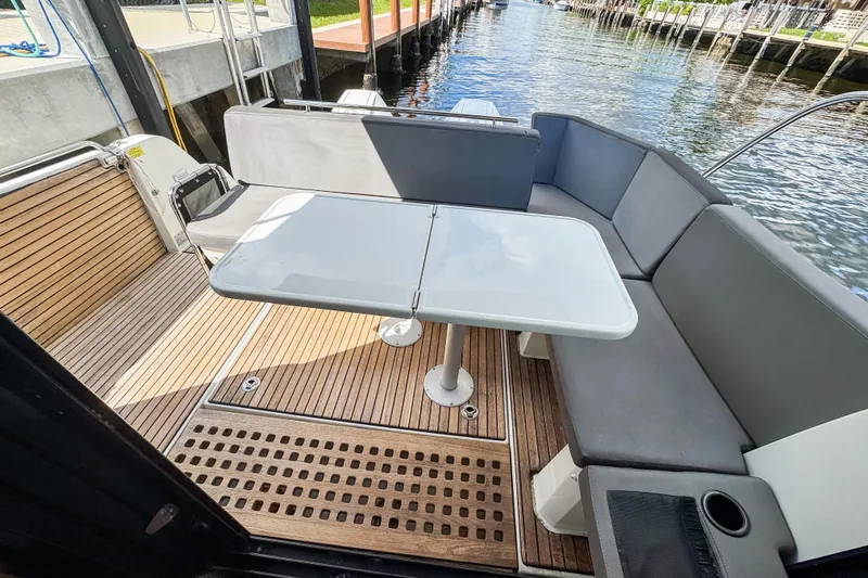  Yacht Photos Pics Beneteau Antares 11 (2022) boat deck with seating and table, docked by water.