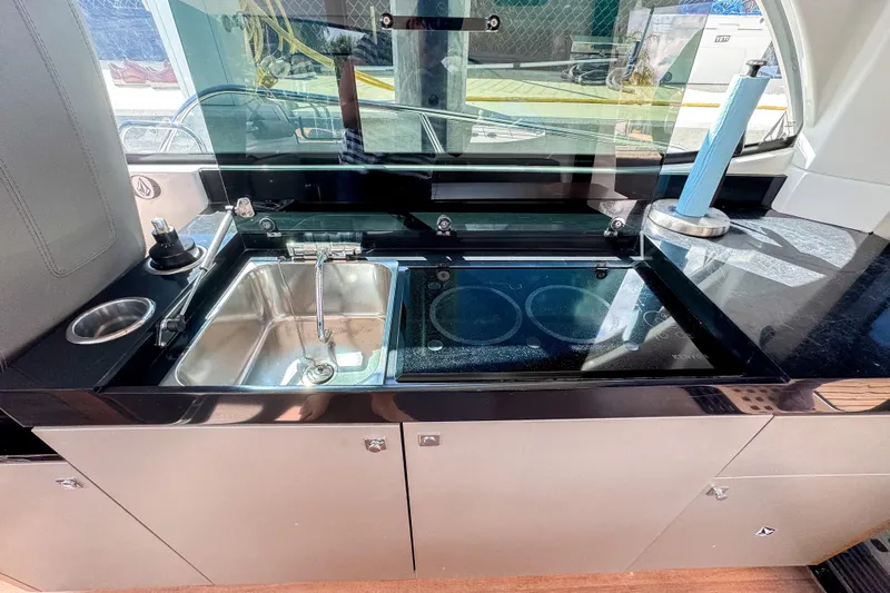  Yacht Photos Pics Modern kitchen area on 2022 Beneteau Antares 11 yacht with sink and stove.