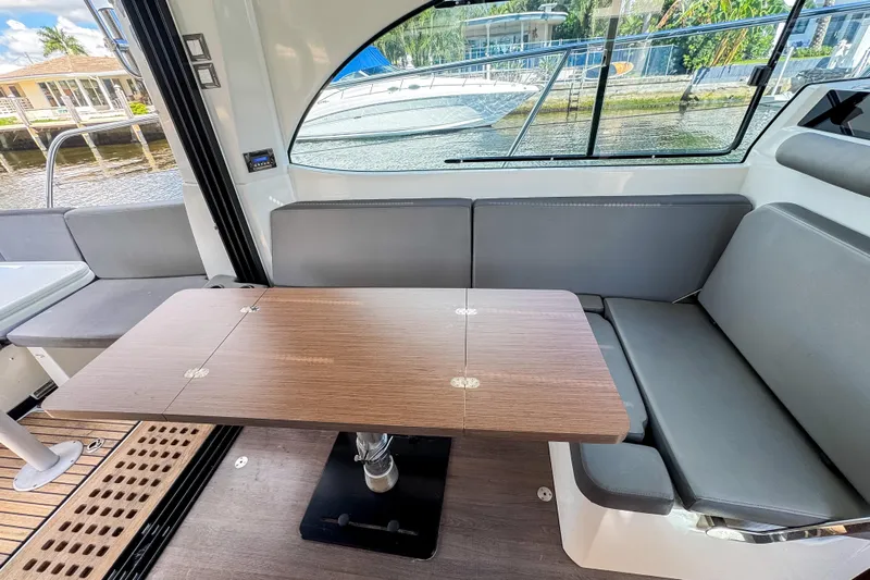  Yacht Photos Pics Interior of 2022 Beneteau Antares 11 with modern seating and wooden table.