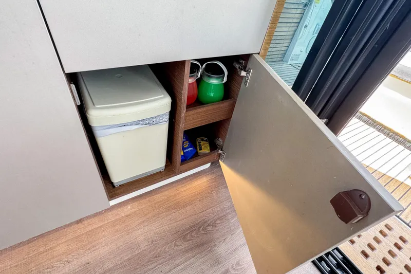  Yacht Photos Pics Cabinet storage on 2022 Beneteau Antares 11 boat with trash bin and supplies.