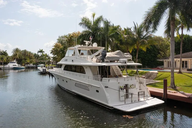  Yacht Photos Pics 2004 Cheoy Lee 84 Bravo Flybridge yacht docked by palm trees in a serene canal.