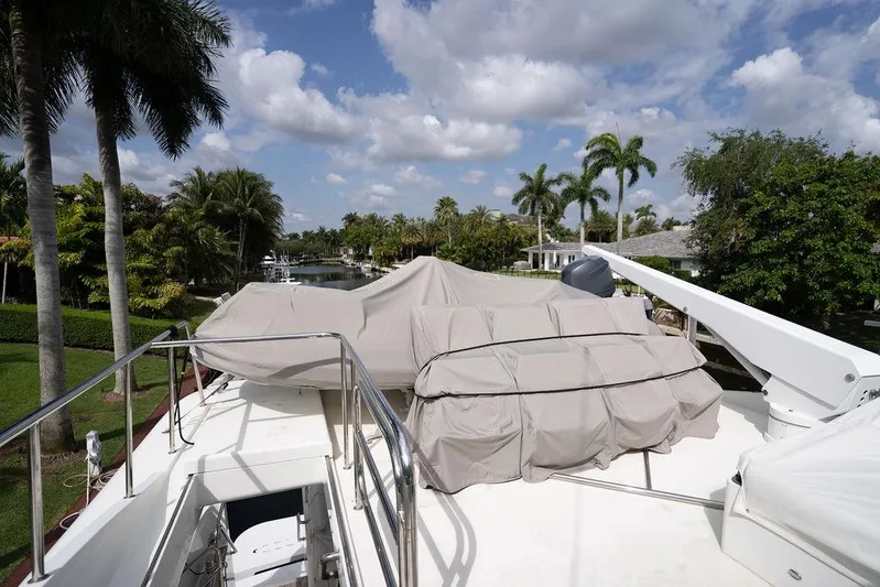  Yacht Photos Pics 2004 Cheoy Lee 84 Bravo Flybridge yacht deck with covered equipment, surrounded by palm trees.