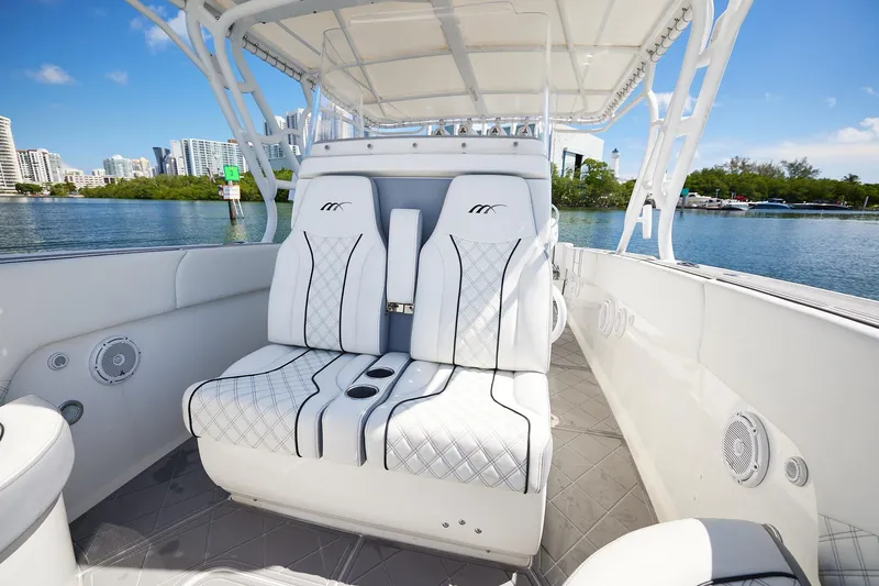  Yacht Photos Pics Luxurious 2007 Midnight Express Cuddy boat interior with white seating, set against a scenic waterfront.