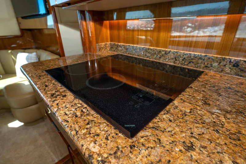 Stay Salty Yacht Photos Pics Luxurious kitchen area in 2009 Viking 50 Convertible yacht with granite countertops and modern cooktop.