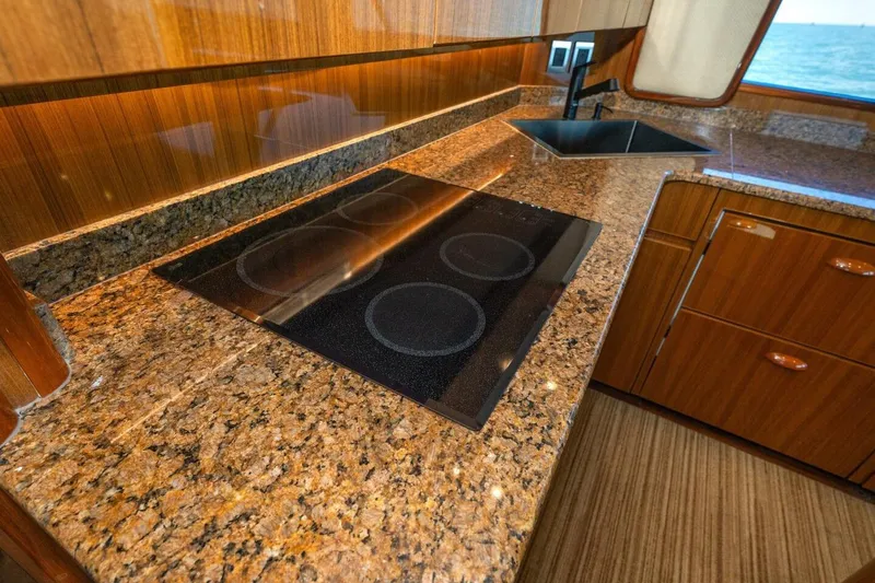 Stay Salty Yacht Photos Pics Luxurious kitchen in 2009 Viking 50 Convertible yacht with granite countertops and modern cooktop.