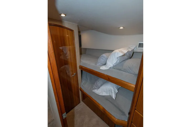 Stay Salty Yacht Photos Pics Bunk beds in 2009 Viking 50 Convertible yacht cabin with wooden door and cozy lighting.