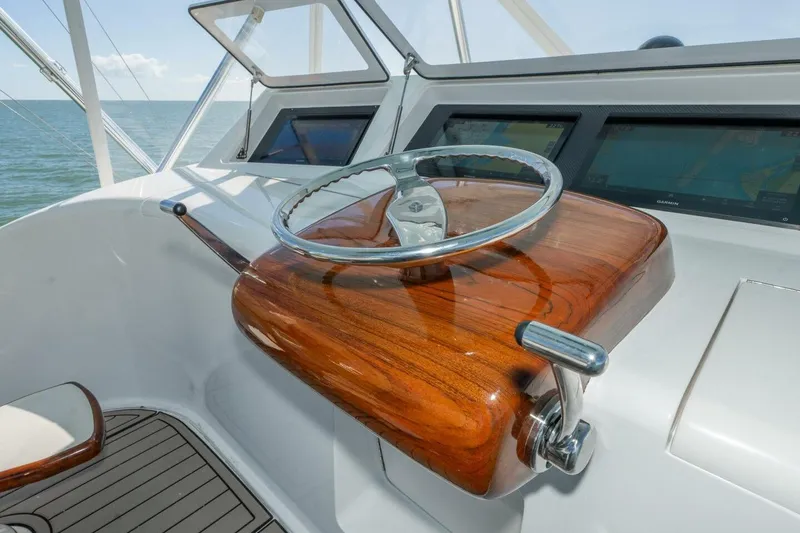 Stay Salty Yacht Photos Pics Steering wheel of 2009 Viking 50 Convertible yacht with wooden helm and navigation screens.