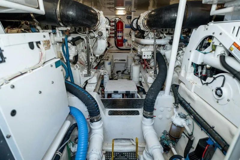 Stay Salty Yacht Photos Pics Engine room of a 2009 Viking 50 Convertible yacht, showcasing machinery and piping.