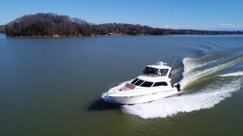  Yacht Photos Pics 2001 Sea Ray 480 Sedan Bridge cruising on a serene lake.