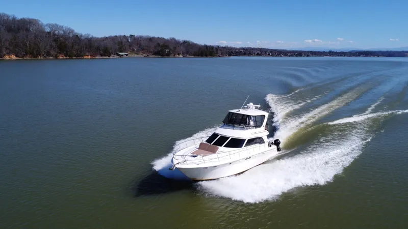  Yacht Photos Pics 2001 Sea Ray 480 Sedan Bridge cruising on a serene lake.