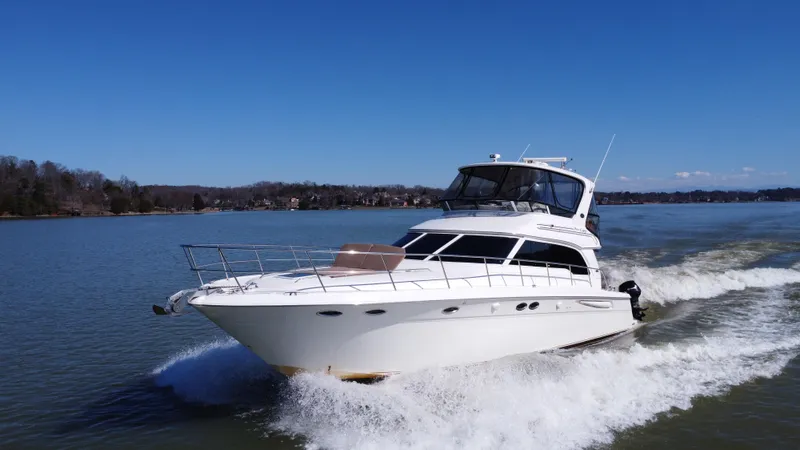  Yacht Photos Pics 2001 Sea Ray 480 Sedan Bridge cruising on a calm lake under clear blue skies.