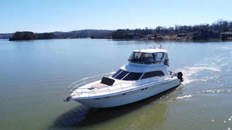  Yacht Photos Pics 2001 Sea Ray 480 Sedan Bridge yacht cruising on a serene lake.