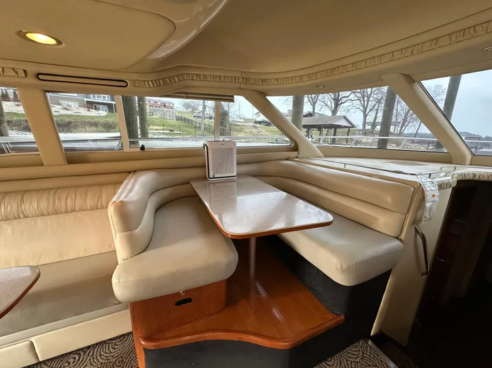  Yacht Photos Pics Interior of 2001 Sea Ray 480 Sedan Bridge with beige seating and wooden table.