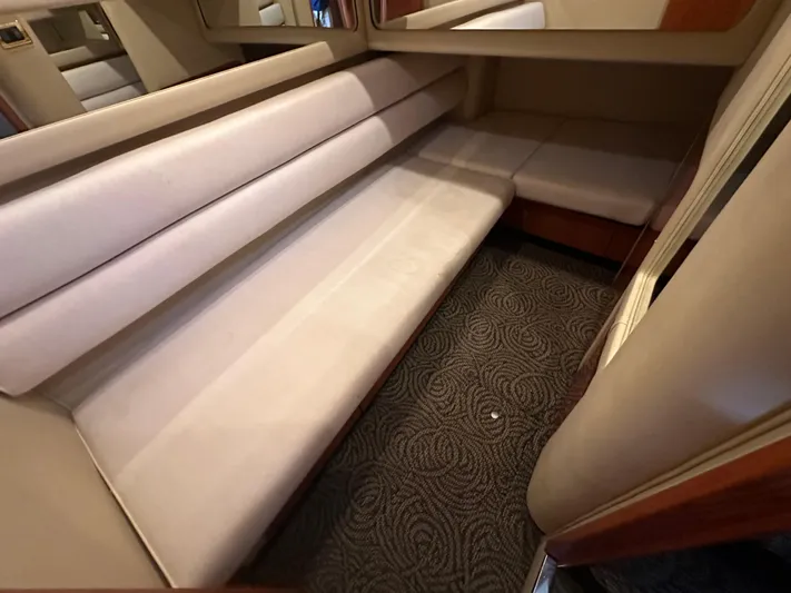  Yacht Photos Pics Interior seating area of 2001 Sea Ray 480 Sedan Bridge with beige upholstery and patterned carpet.
