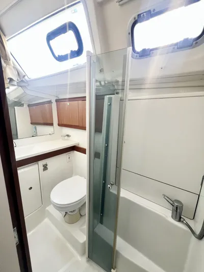 Island Time Ll Yacht Photos Pics 2008 Beneteau 46 yacht bathroom with shower, toilet, and wooden cabinets.