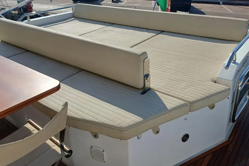  Yacht Photos Pics Luxurious seating area on 2018 Azimut 77S yacht with beige cushions and wooden table.