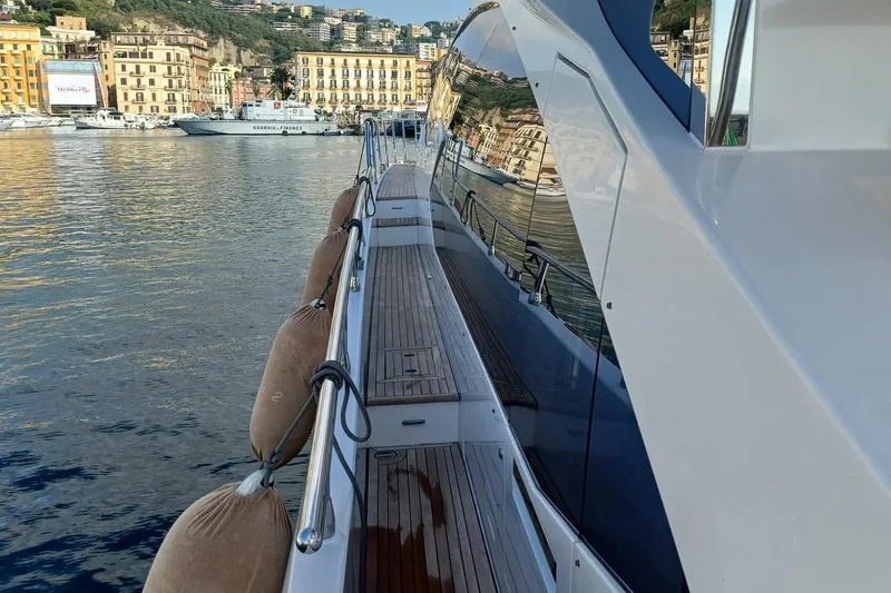  Yacht Photos Pics Azimut 77S yacht docked in scenic harbor, reflecting coastal buildings, 2018 model.