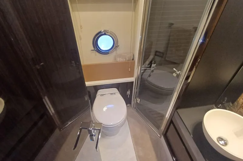  Yacht Photos Pics Luxurious bathroom on 2018 Azimut 77S yacht with modern fixtures and porthole window.