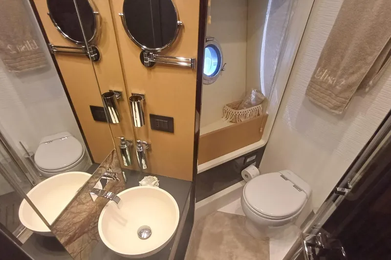  Yacht Photos Pics Luxurious bathroom in 2018 Azimut 77S yacht with modern fixtures and porthole window.
