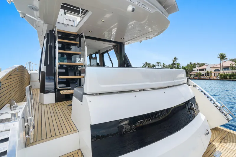  Yacht Photos Pics 2021 Galeon 500 Fly yacht with sleek design and wooden deck by the water.